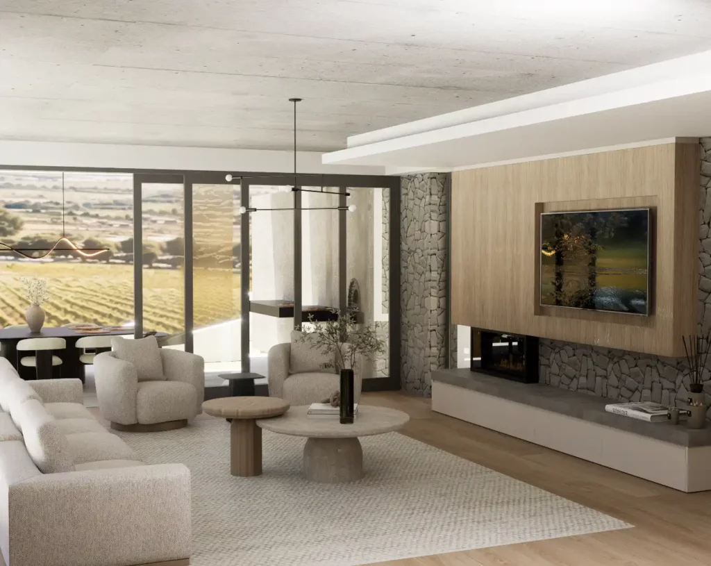 A modern living room with a stone accent wall, a wall-mounted TV over a fireplace, cream seating, and large windows looking out onto a vineyard.