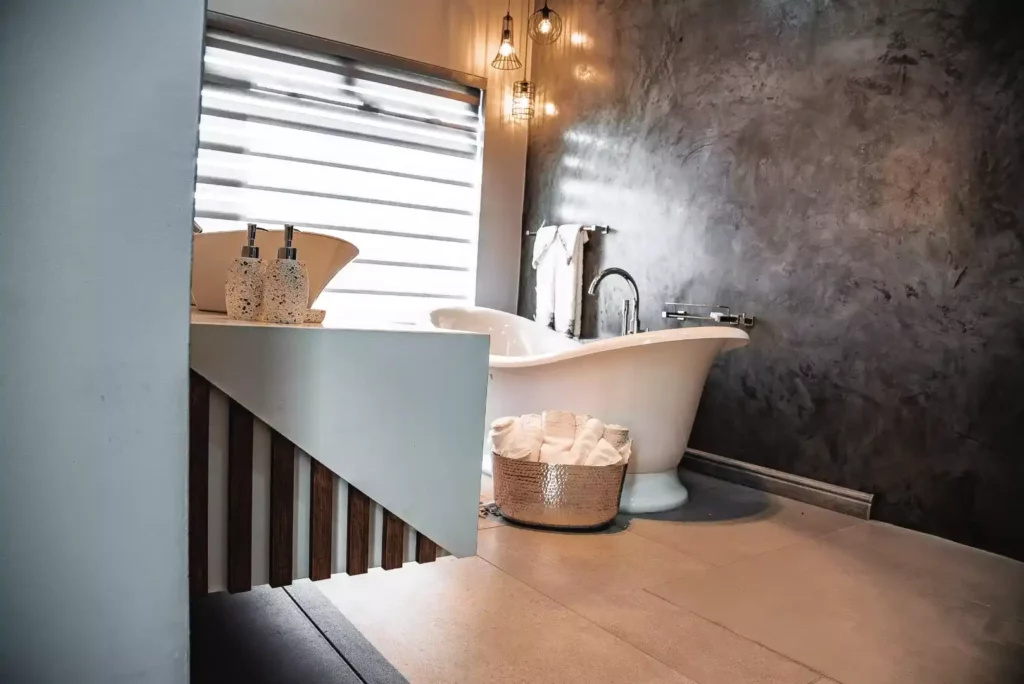 Modern bathroom featuring a freestanding tub against a dark textured wall and a sleek floating vanity.