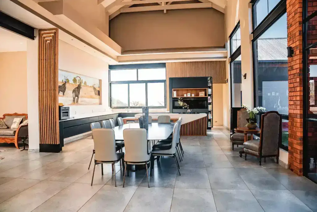 Spacious open-plan living area with a modern kitchen, dining table, and high vaulted ceilings.